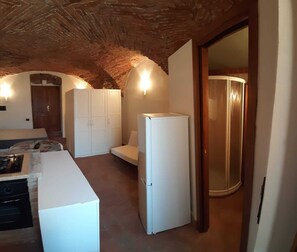 Eine kleine Küche mit einem weißen Kühlschrank, einem Herd und Schränken.