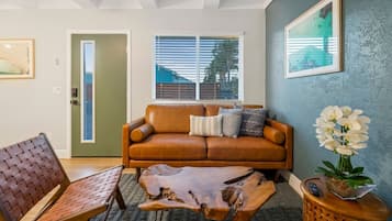 A living room with a brown leather sofa, a wooden coffee table, and a patterned rug.
