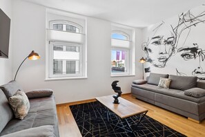 A modern living room with two sofas, a coffee table, and a wall art piece. - Arbio I Modern Art Suite for 6 (Leipzig)