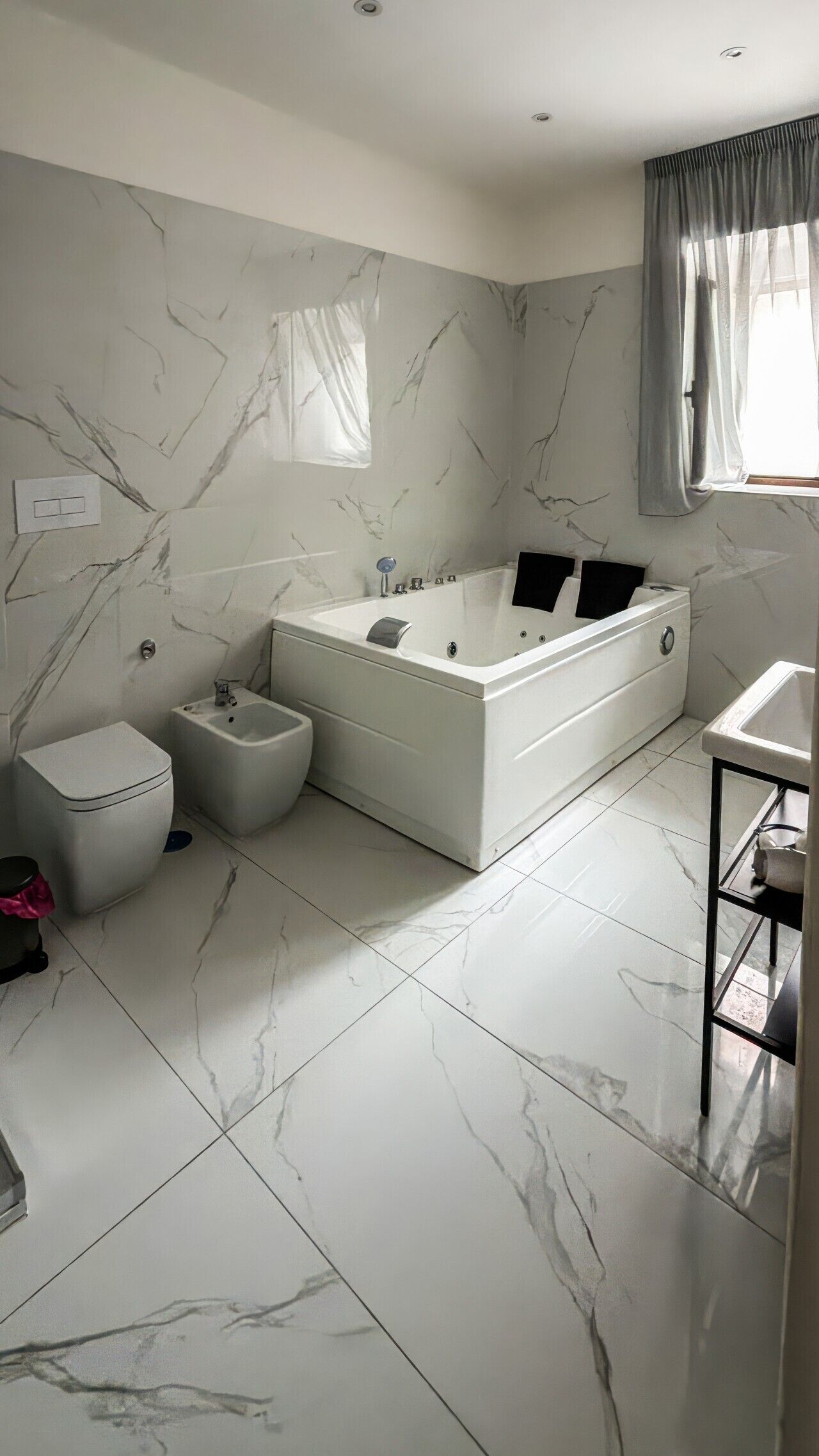 Un bagno con una vasca da bagno grande, un bidet, un water e un lavabo.