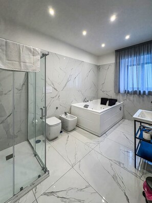 A modern bathroom with a glass shower enclosure, a toilet, a bidet, a bathtub, and a vanity with a sink. - B&B Patty and Mary - Room with Jacuzzi (Napoli)