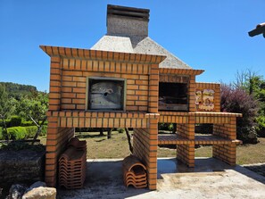 A brick-built outdoor oven structure with a chimney, a window, and a decorative painting. - House with private pool in the heart of the Douro - ideal for families (Paços)