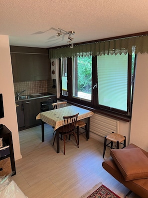 Una cocina compacta con zona de comedor, un taburete pequeño y un banco acolchado.