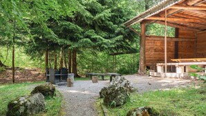 A rustic wooden cabin with a gravel path leading to a picnic table and benches. - Cozy Alpine Studio in Wiriehorn with Parking (Diemtigen)