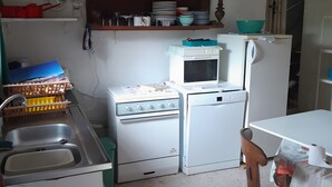 Una cucina compatta con lavello, piano cottura, forno a microonde e frigorifero.