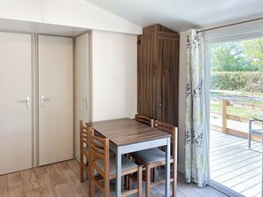 A room with a wooden table and chairs, a sliding door, and a view of a garden through a glass door. - Unit 1 – Tournesols
Spacious, Relaxing, Ready for Your Next Holiday (Lévignac-de-Guyenne)