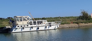 A boat with a cabin, windows, and a flag.