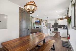 Eine moderne Küche mit Holztisch, integrierten Geräten und einem großen Fenster.