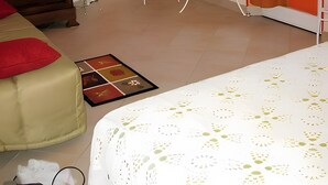 A room with a bed, a small table with a lamp, a chair, and a window with curtains. - Bed and Breakfast 'L'églantier' (Bonnée)