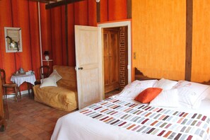 Ein Zimmer mit Bett, Stuhl, Tisch und Tür.