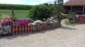 A gravel path leading to a rustic building with a stone wall and potted plants. - Bed and Breakfast 'Volière' with Wi-Fi (Bonnée)