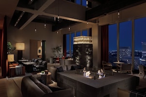A modern living room with a fireplace, seating, and a city view.
