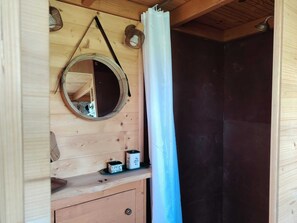 A wooden cabin interior with a mirror, a hanging light fixture, and a shower curtain. - Tiny house at the educational farm | Spa included | 1h30 from Paris (Villiers-Saint-Orien)