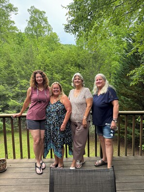 A group of people standing on a wooden deck with a forested background. - 3-bedroom country house in charming Murphy with AC (Murphy)