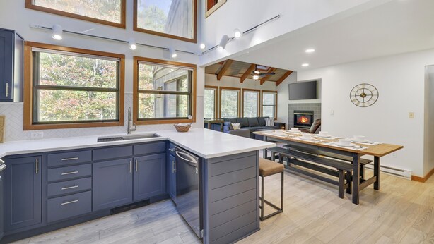Una cocina moderna con una isla grande, electrodomésticos integrados y ventanas amplias.