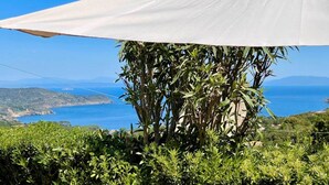 A white umbrella structure with a view of the sea and hills in the background. - Malea by ColombiElbaVacanze (Capoliveri)