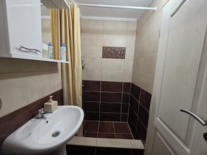Une salle de bain avec un lavabo, une douche et des toilettes.
