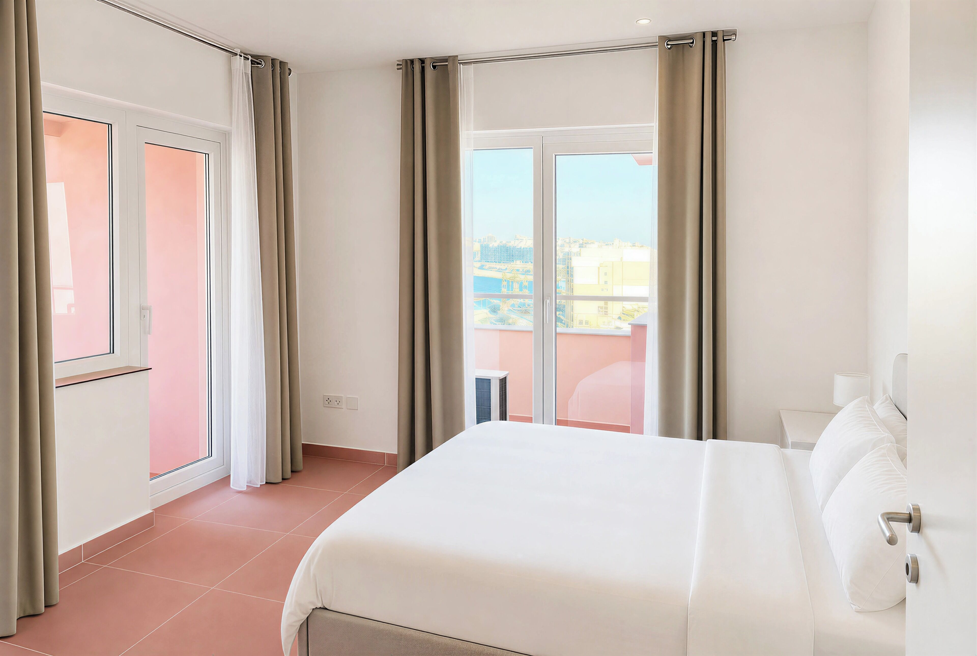 Quarto de hotel com cama, cortinas, janela e vista para a cidade.