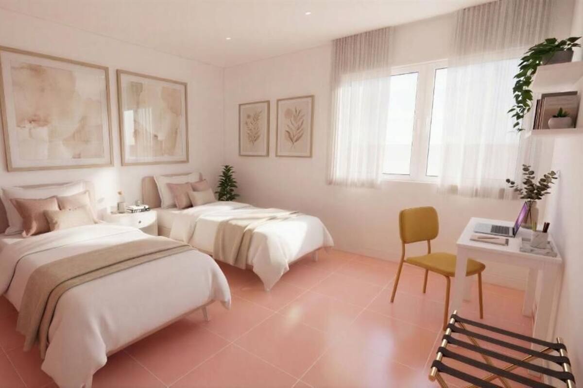 Ein Schlafzimmer mit zwei Betten, einem Schreibtisch und einem Stuhl.