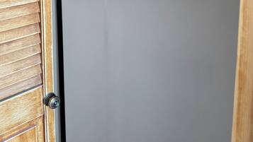 A wooden closet with a metal rod holding wooden hangers.
