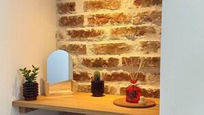 A wooden shelf with decorative items against a brick wall. - Cosy apartment on the banks of the Nivernais Canal (Saint-Léger-des-Vignes)