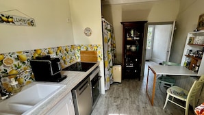Una cocina compacta con un lavamanos, una cafetera y un refrigerador.