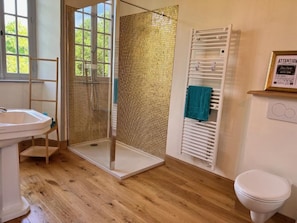 A bathroom with a shower, a sink, a toilet, and a towel rack. - Château de Planquery (Planquery)