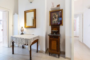 Quarto com um armário de madeira, um espelho emoldurado e uma mesa com toalha de renda.