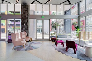 Eine moderne Lobby mit Glastür, Sitzbereichen und Blick auf die Straße.