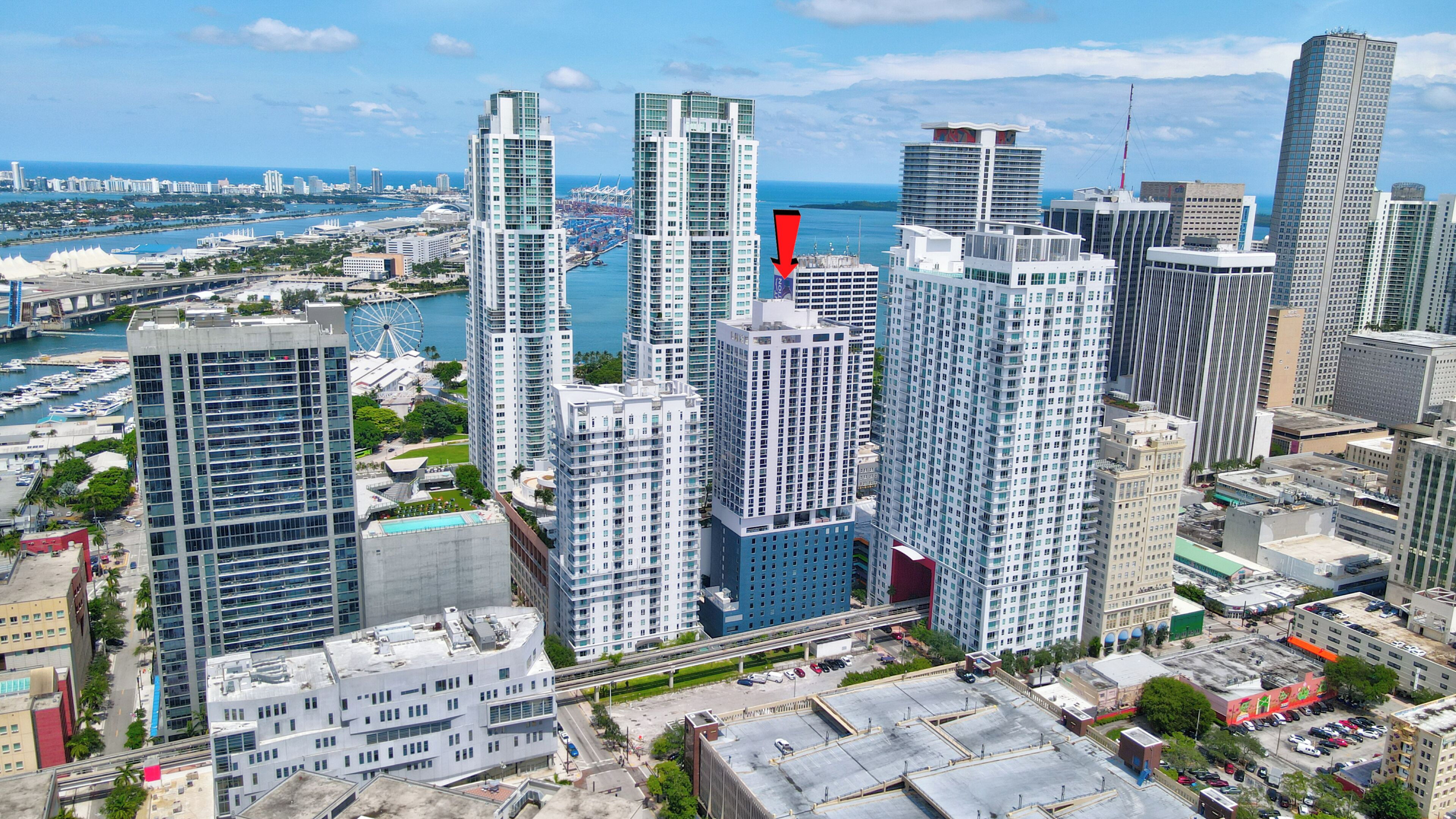A high-rise urban area with modern skyscrapers, a marina, and a Ferris wheel.