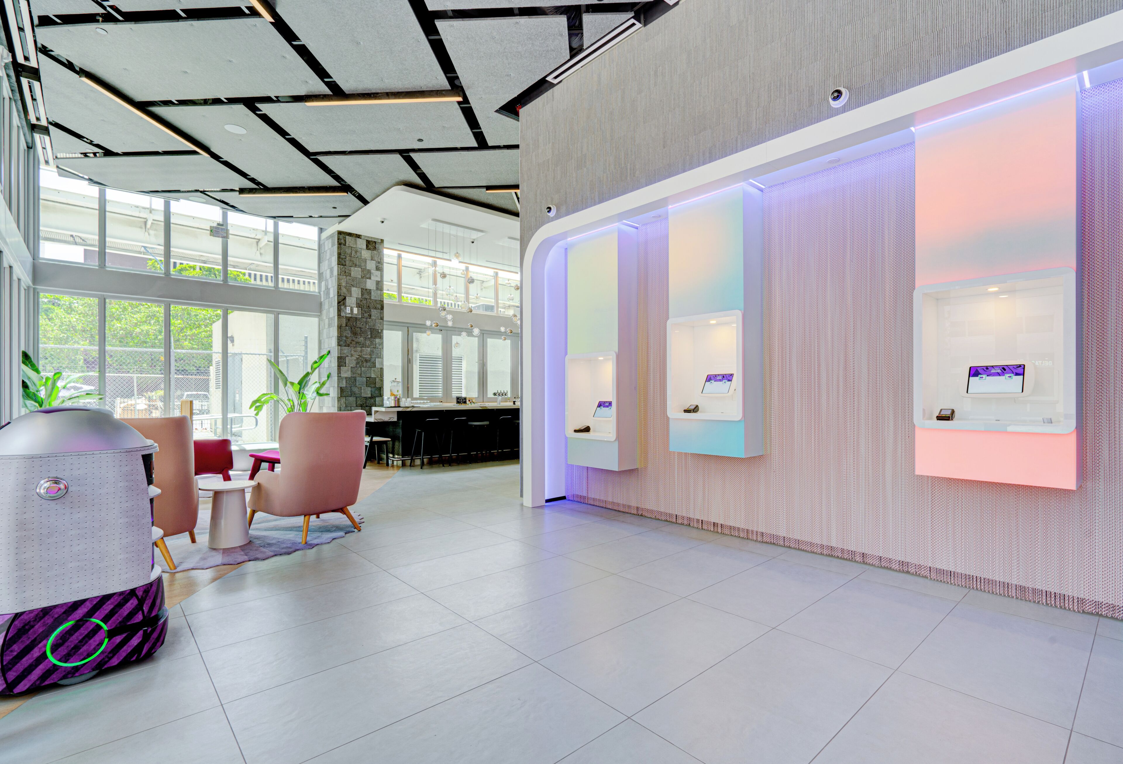 Eine moderne Lobby mit Empfangstresen, Sitzgelegenheiten und großen Fenstern.