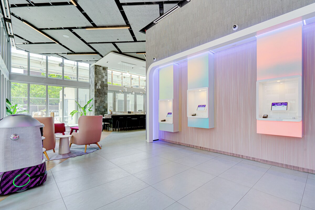 Eine moderne Lobby mit Empfangstresen, Sitzgelegenheiten und großen Fenstern.