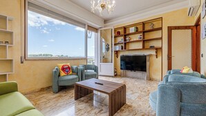Ein Wohnzimmer mit Kamin, großem Fenster und einer Kandelaber.