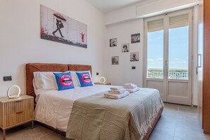 A bedroom with a bed, a nightstand, a mirror, a window with a view, and a door. - Spacious apartment a few steps from the historic center of Siena with terrace (Siena)