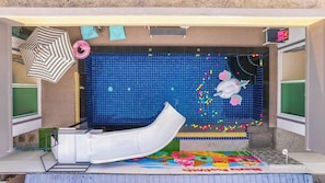 A children's play area with a slide, pool, and colorful decorations.