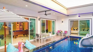 An indoor swimming pool with a slide, lounge chairs, and a pool table. - Sunday Villa Green Shawty Pattaya (Bang Lamung)
