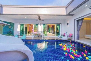 A swimming pool with colorful balls, a ceiling fan, and a view of the interior. - Sunday Villa Green Shawty Pattaya (Bang Lamung)