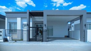 A modern building with a covered entrance, a gated driveway, and a clear sky. - Sunday Villa Green Shawty Pattaya (Bang Lamung)