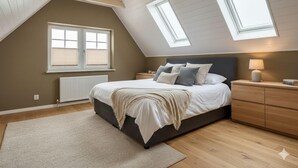 Una camera da letto con soffitto spiovente, lucernari, un letto, comodini e un tavolino.