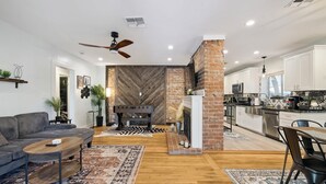 Una sala moderna con chimenea, comedor y cocina.