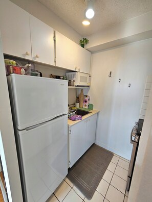 A compact kitchen with a refrigerator, microwave, and sink. - High-rise apt in downtown of Montreal (Montreal)