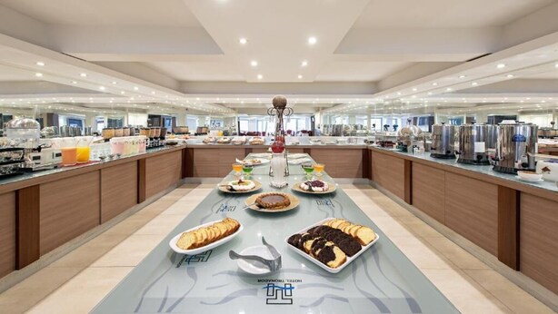 A hotel breakfast buffet with various food items and beverages. - Hotel Tronador (Mar del Plata)