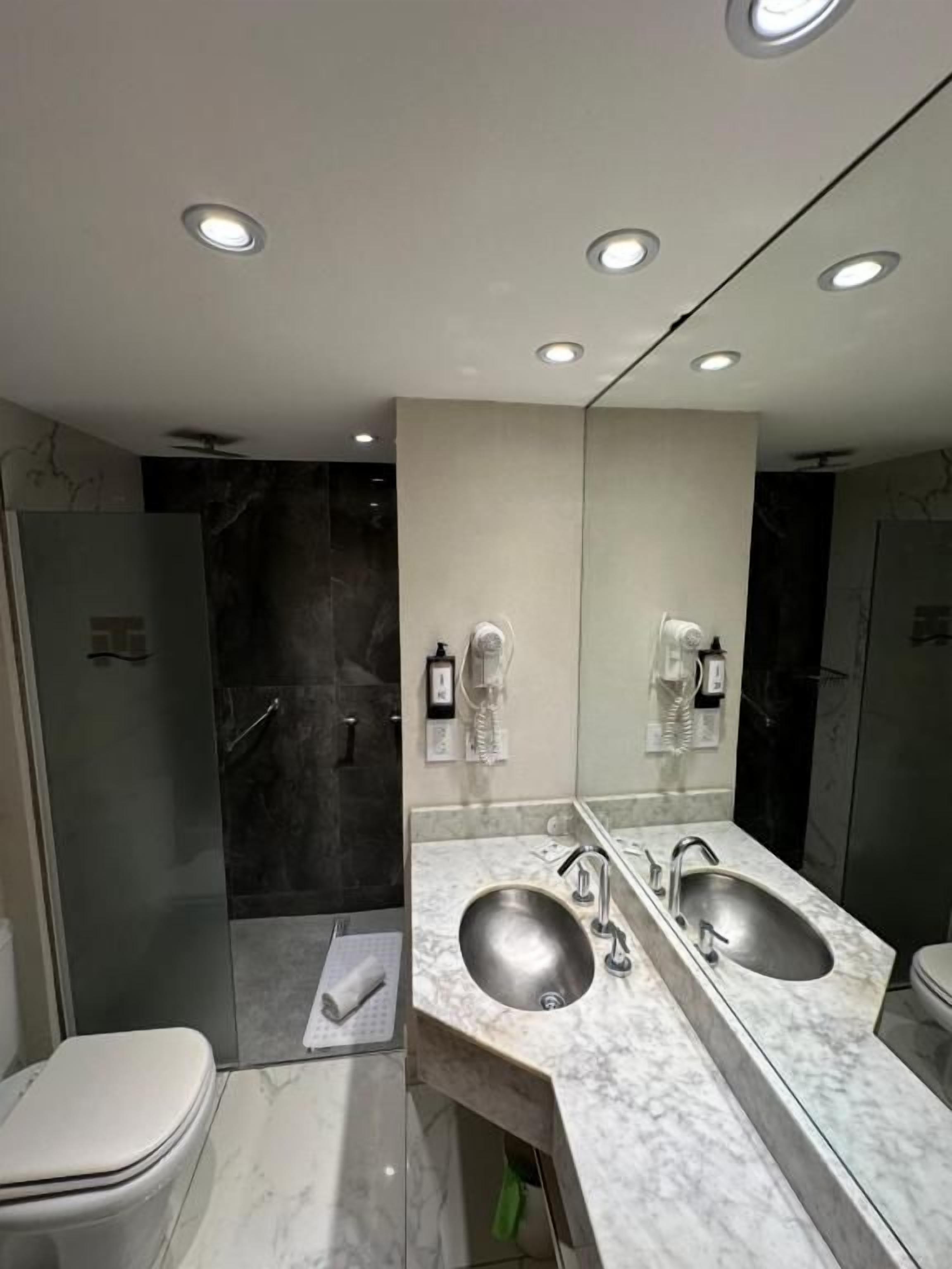 Un baño moderno con lavamanos doble, inodoro y zona de ducha.