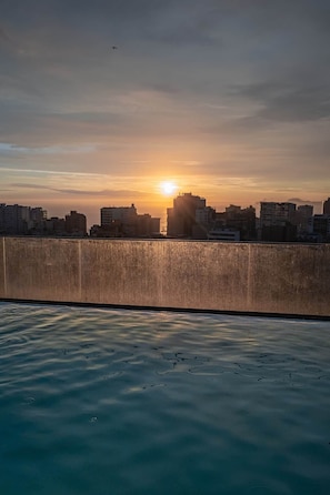 A sunset over a city skyline with buildings silhouetted against the sky. - 2 bedrooms with A/C, 2 bathrooms, desk, pool in Larco (Miraflores)