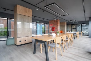 A modern conference room with a long table, chairs, and a brick accent wall. - Studio with AC, desk, view and pool in Larco (Miraflores)