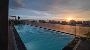 A rooftop swimming pool with a cityscape view during sunset. - Bright Premium AC 1BR · Larco · 24h Reception (Miraflores)