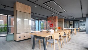 Une salle de conférence moderne, dotée d’une longue table, de chaises et d’un mur décoratif en briques.