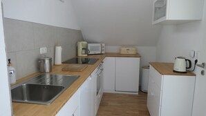 A compact kitchen with a sink, a microwave, a toaster, and a coffee maker. - Upstairs6b (Dipperz)