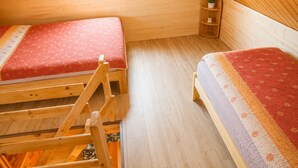 A small, cozy room with two wooden bunk beds, a small shelf with a plant, and a window. - Cottages for 4 People With a Swimming Pool, Dziwnowek (Kamien Pomorski)