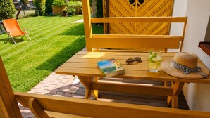 A wooden outdoor table with a book, sunglasses, and a drink on it. - Cottages for 4 People With a Swimming Pool, Dziwnowek (Kamien Pomorski)